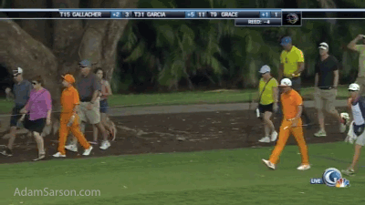 Rickie Fowler walks with one of his fans.